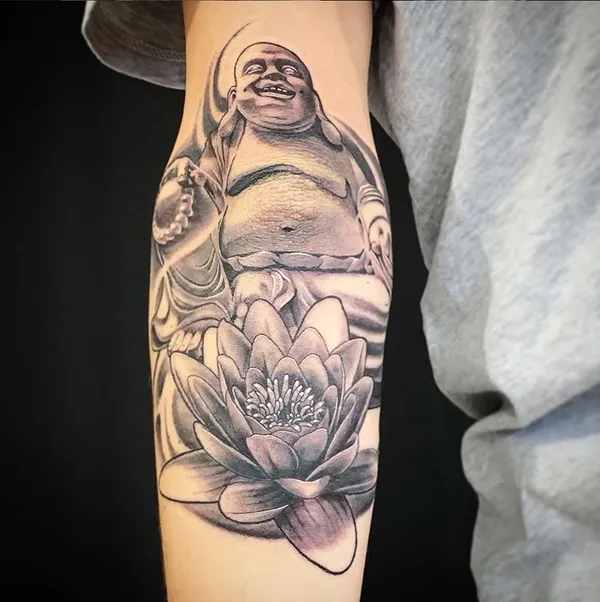 Lachender Buddha über einer Lotusblüte auf dem Unterarm